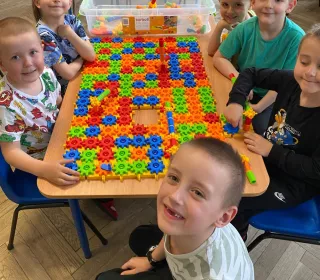 zdjęcie dzieci podczas nauki i zabawy z wykorzystaniem pomocy naukowych - klocków